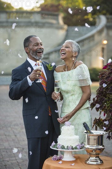 Flower petals falling on Black newlyweds