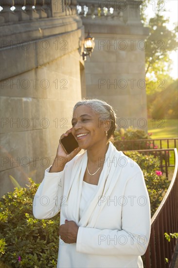 Black woman talking on cell phone near stone staircase