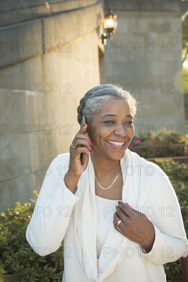 Black woman talking on cell phone near stone staircase