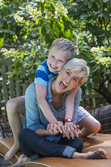 Caucasian mother and son playing on sofa outdoors