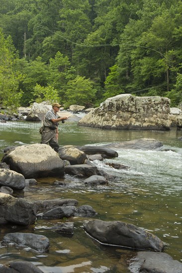 Caucasian man fishing in river