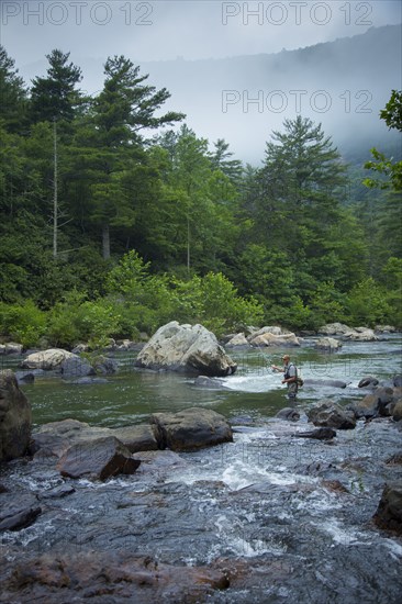 Caucasian man fishing in river