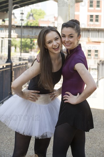 Portrait of smiling Caucasian ballerinas standing outdoors