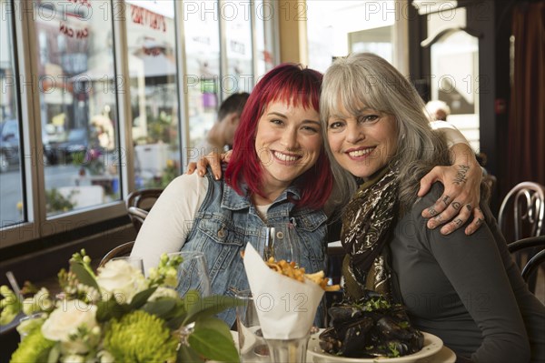 Caucasian women hugging in restaurant