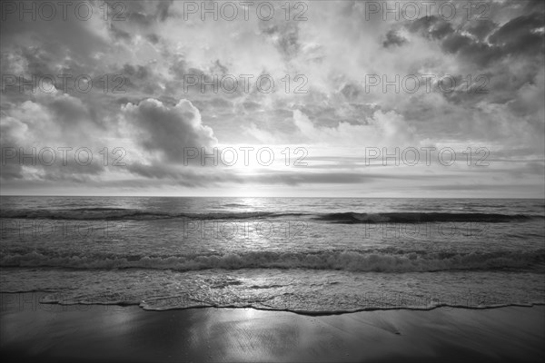 Ocean waves on beach at sunset