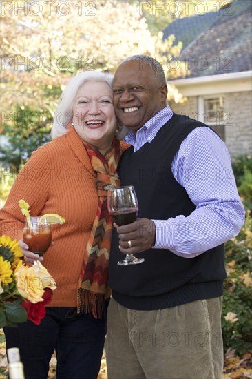 Couple hugging outdoors and enjoying wine and cocktail