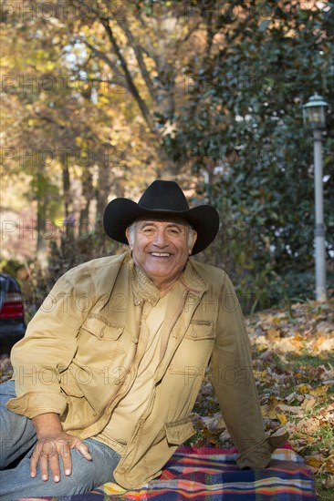 Portrait of Hispanic man sitting on blanket outdoors