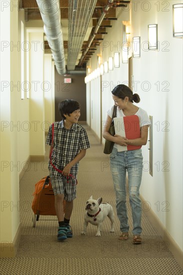 Asian mother and son in corridor with dog