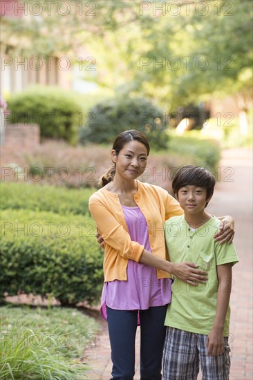 Portrait of Asian mother and son standing on sidewalk