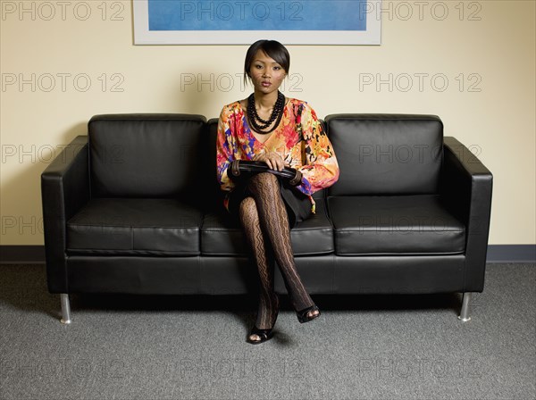 Mixed race businesswoman waiting in lobby