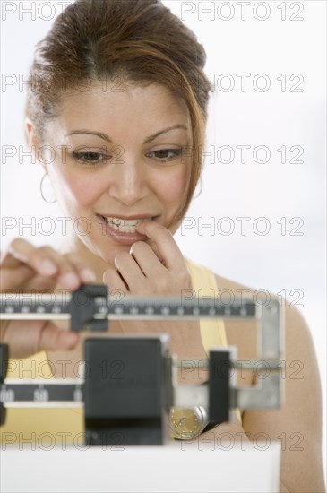 Woman weighing herself on scale