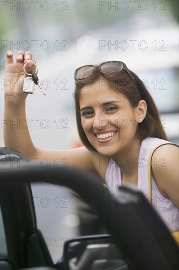 Portrait of woman holding keys in hand