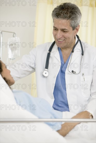 Male doctor talking to female patient in hospital