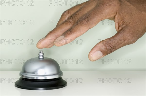 Close up of hand ringing service bell