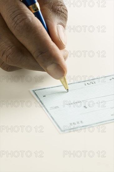 Close up of hand writing check