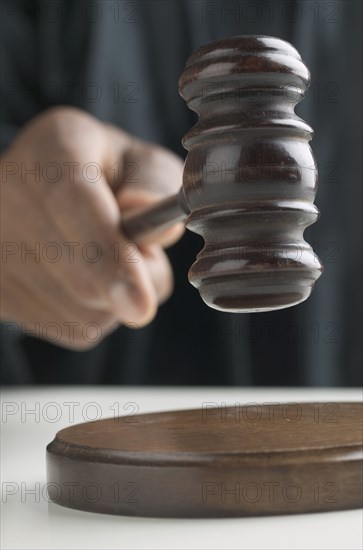 Close up of hand pounding gavel