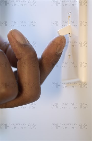 Close up of finger flipping light switch