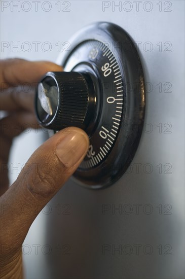 Close up of fingers turning combination lock