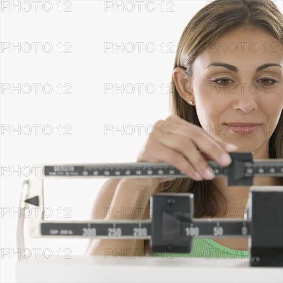 Woman weighing herself on scale