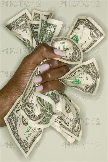 Close up of hands squeezing dollar bills