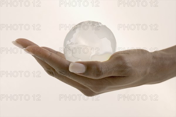 Close up of hand holding globe