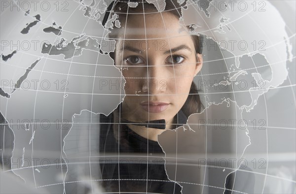 Portrait of woman looking through glass globe