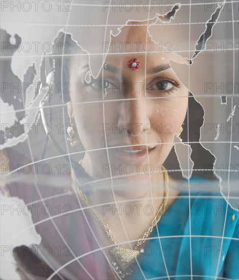 Woman in traditional Indian dress behind globe