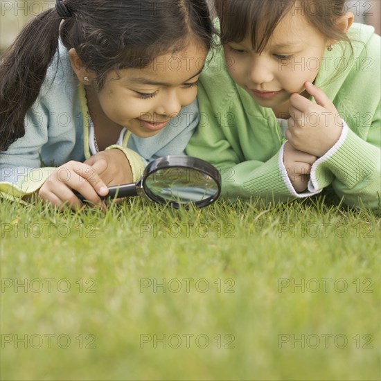 Two girls using a magnifying glass