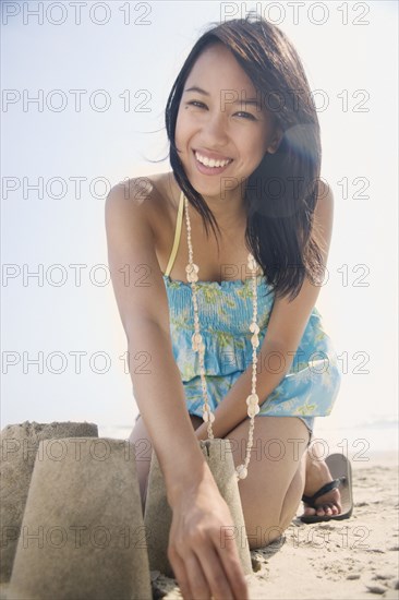 Portrait of woman building sandcastle