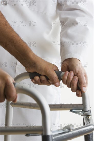 Mid view of doctor assisting patient with walker