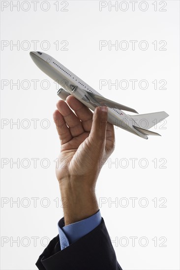 Close up of hand holding toy airplane in air