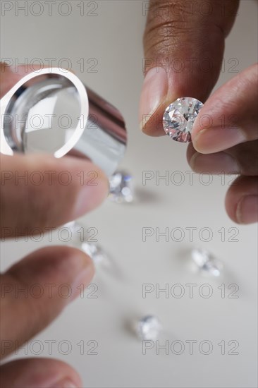 Close up of hands examining diamonds