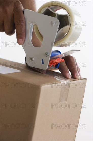 Close up of hands taping up box