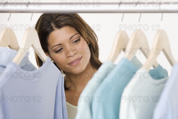 Woman looking at shirts in closet