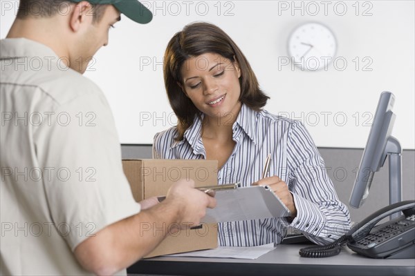 Man delivering package for woman to sign for