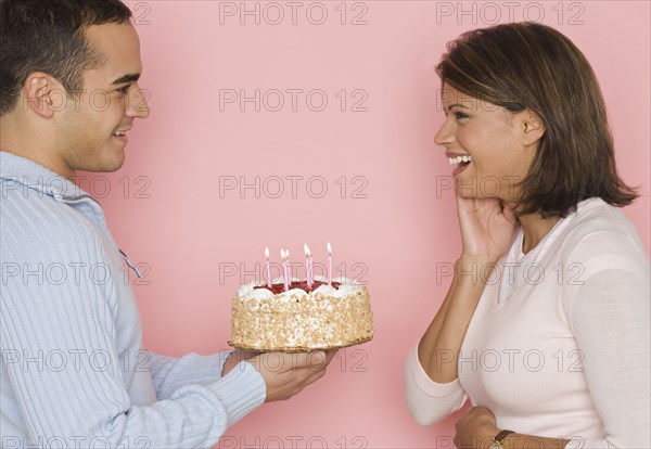 Profile of man holding cake and looking at woman