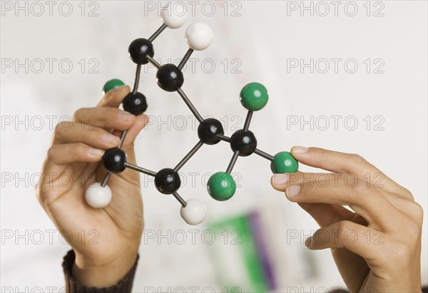 Close up of hands holding science model