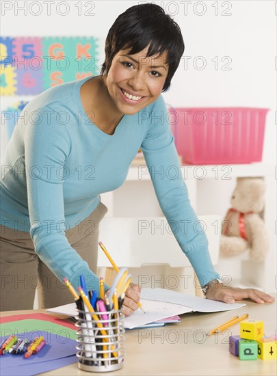 Portrait of woman writing in notebook at desk