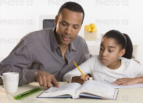 Father helping daughter with homework