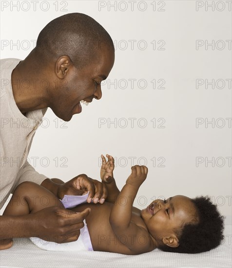 Father changing his baby daughter's diaper