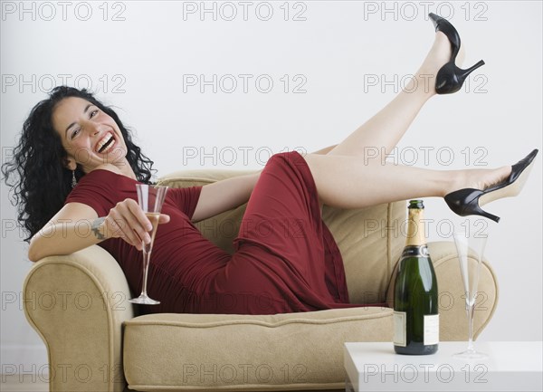 Young woman relaxing with wine at dinner party