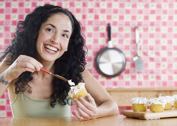 Young woman frosting cupcakes