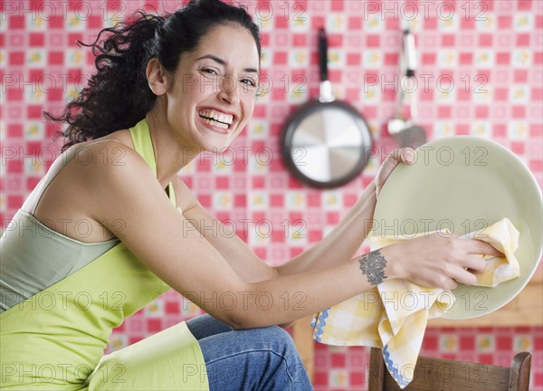 Young woman drying a plate