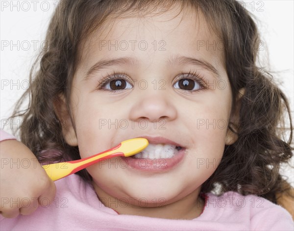 Close up portrait of little girl brushing teeth