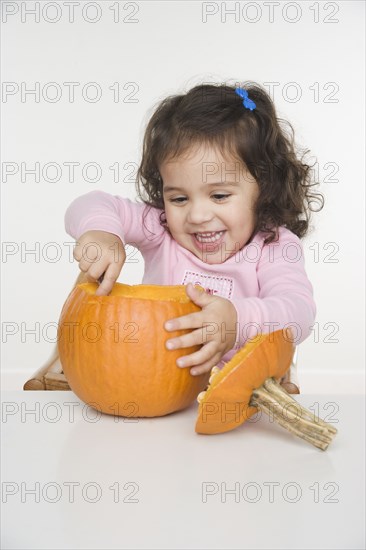 Little girl carving pumpkin