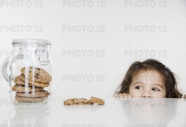 Little girl looking at cookie jar