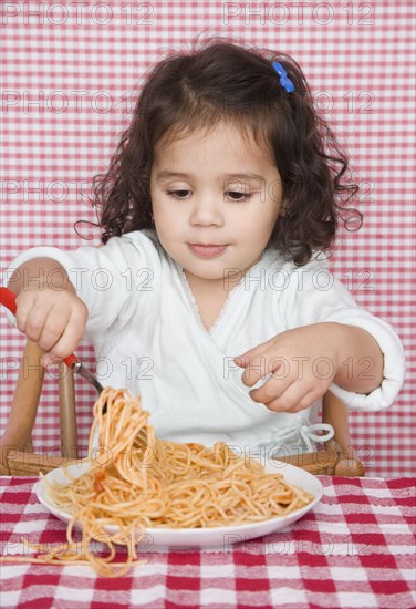 Young girl eating spaghetti