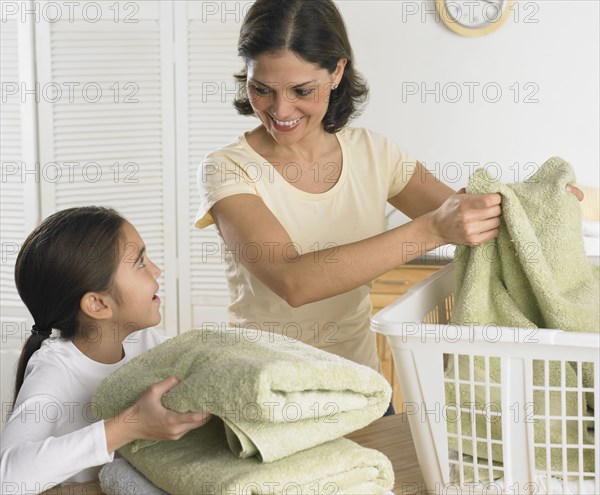 Mother and daughter folding laundry together