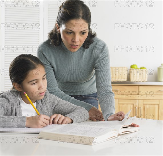 Mother helping her daughter with her homework