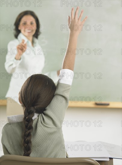 Young girl raising her hand in class